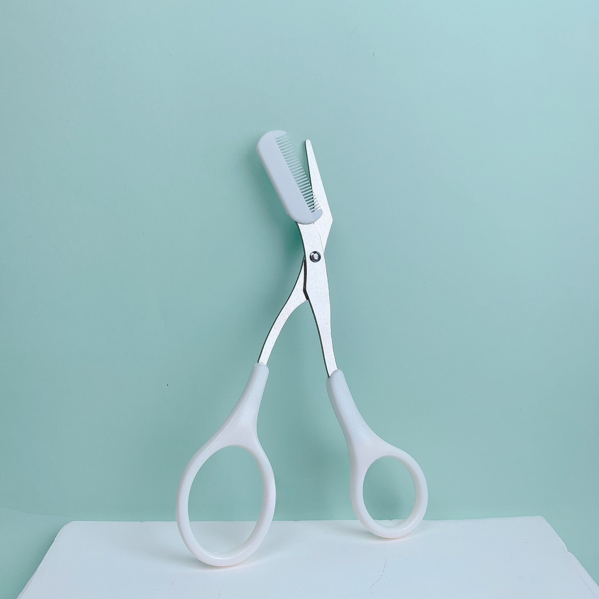 Stainless steel pink eyebrow trimming scissors with built-in comb for precise grooming and perfect eyebrows